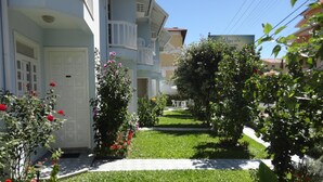 A residential building with a well-maintained garden, a white door, and a visible balcony. - Pousada Belo Mar (Florianopolis)