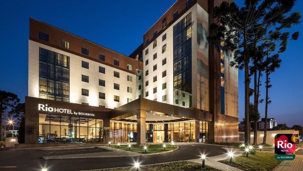 Un hôtel moderne doté d’une entrée imposante, de plusieurs étages et d’une façade bien éclairée.