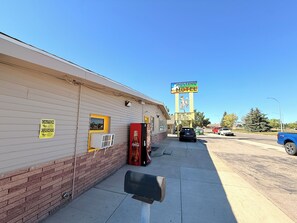 A motel with a large sign, a Coca-Cola refrigerator, and a mailbox. - Mustang Motel Gillette I-90 (Gillette)