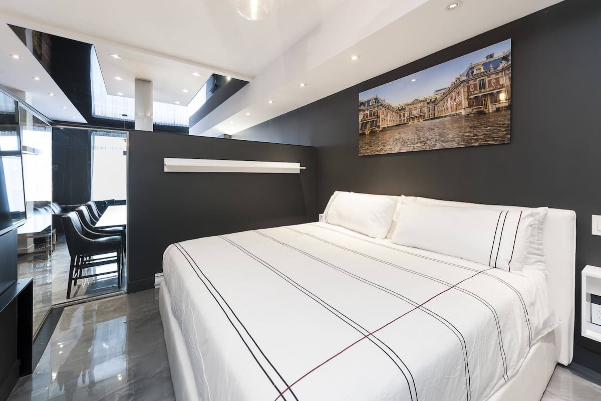 Quarto de hotel moderno com uma cama grande, uma escrivaninha e uma cadeira.