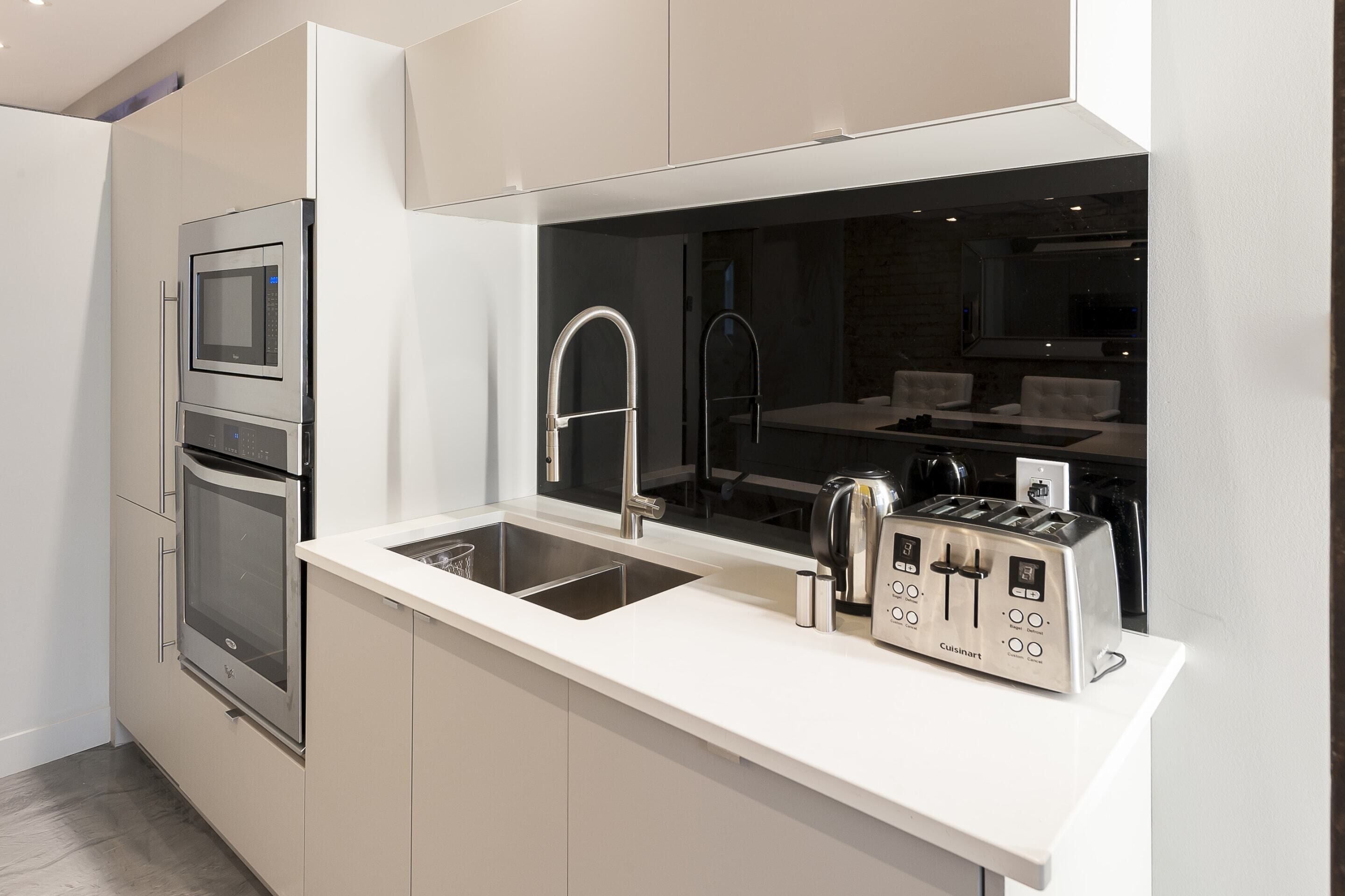 A modern kitchen with stainless steel appliances, a double sink, and a built-in oven.