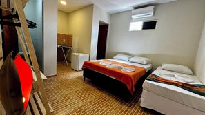 A hotel room with a bed, a smaller bed, a desk, and an air conditioning unit. - Pousada Maresia Centro (Ipojuca)