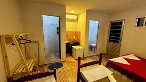 A compact hotel room with a kitchenette, a small bathroom, and a bed with a red cover. - Pousada Maresia Centro (Ipojuca)