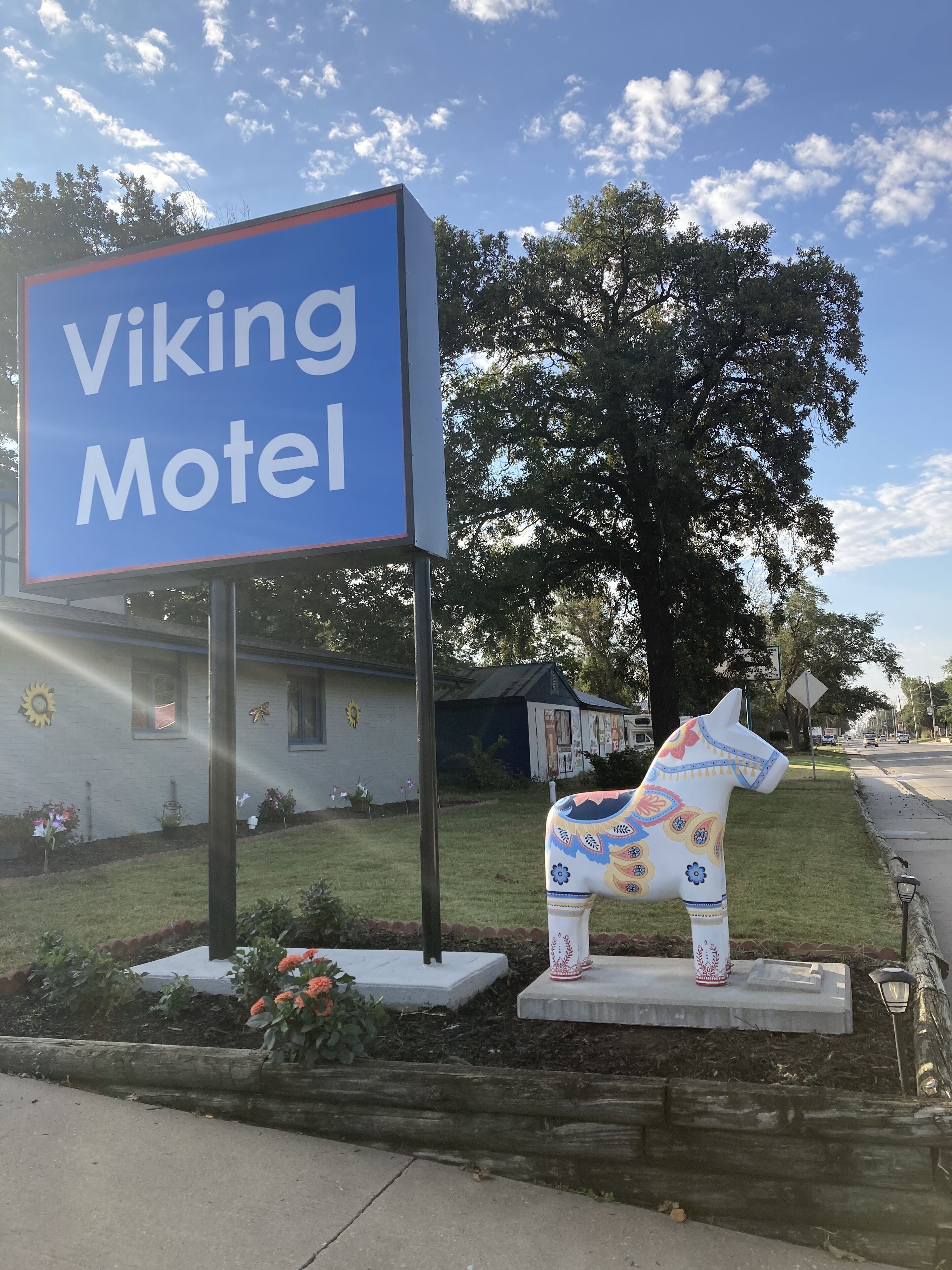A Viking Motel sign with a decorative horse statue in front.