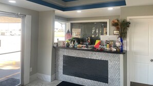 A reception area with a tiled wall, a black fireplace, and a counter with various items. - Viking Motel (Lindsborg)