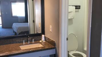A bathroom with a sink, mirror, and toilet.