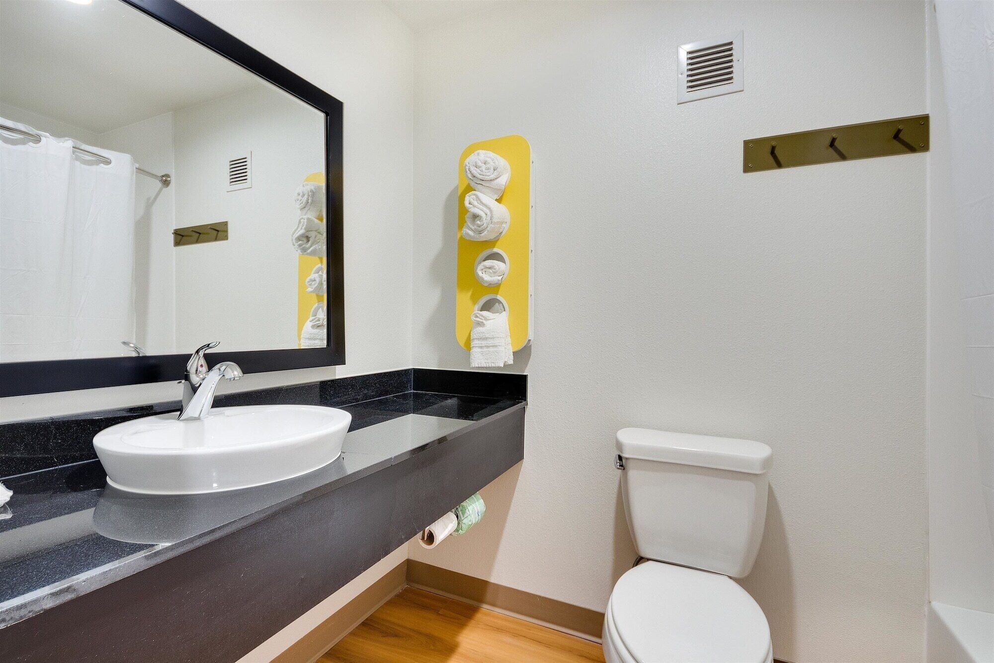 A bathroom with a white sink, a mirror, and a toilet.