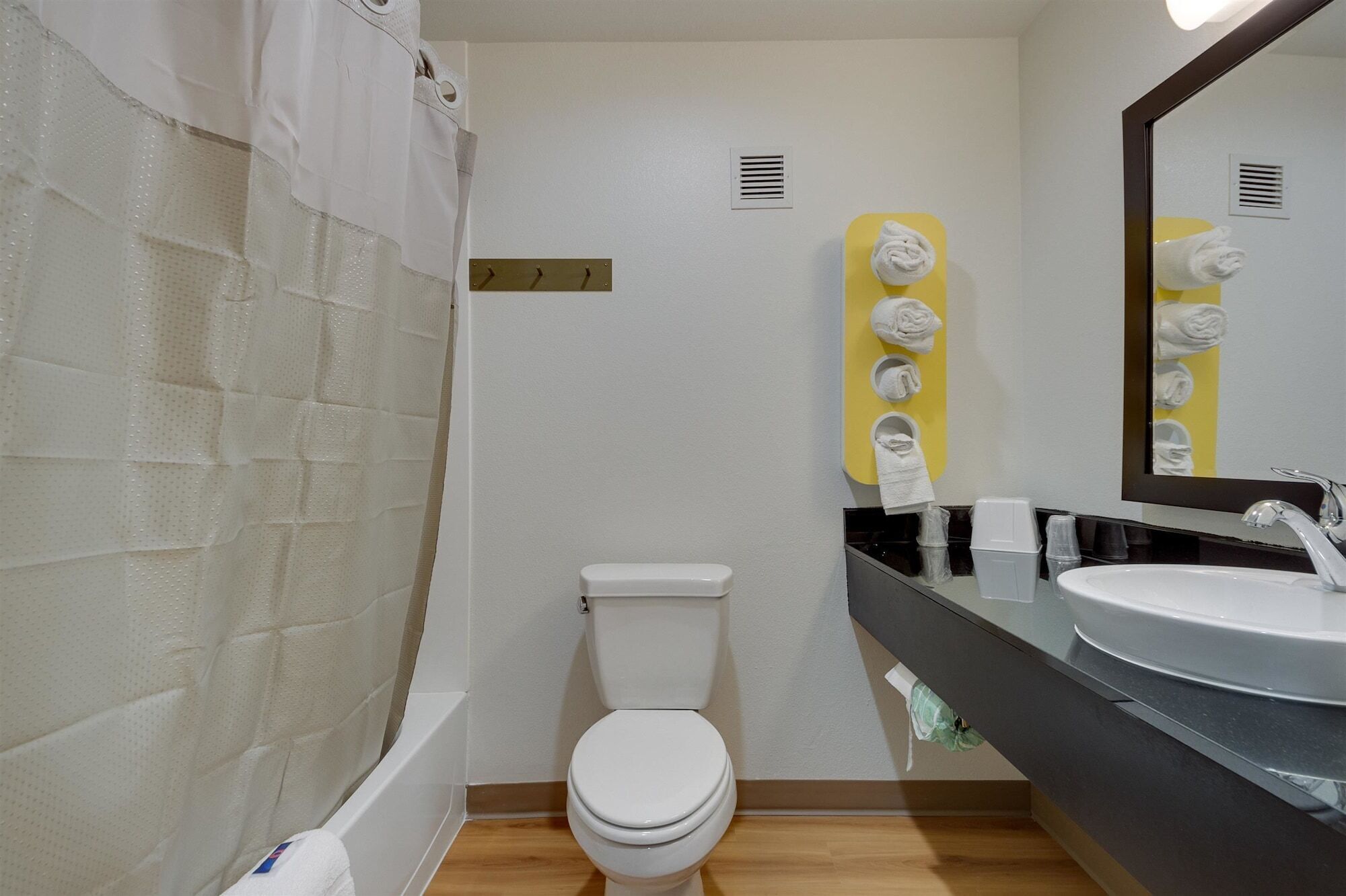 Een moderne badkamer met een bad, toilet en een wastafel met spiegel.