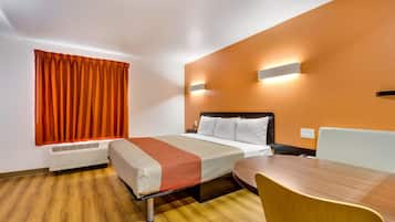 Una habitación de hotel con una cama, una mesa y una silla.