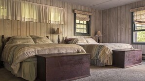 Un dormitorio con dos camas, paneles de cabecera de madera y una ventana con vistas.