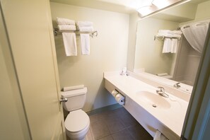A bathroom with a toilet, sink, and towel rack.