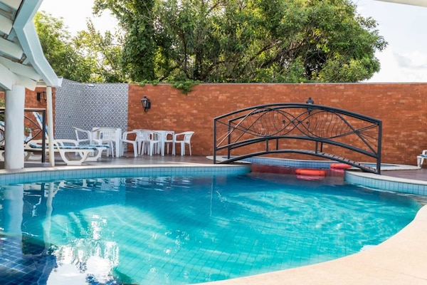 Una piscina al aire libre, sillones reclinables de piscina