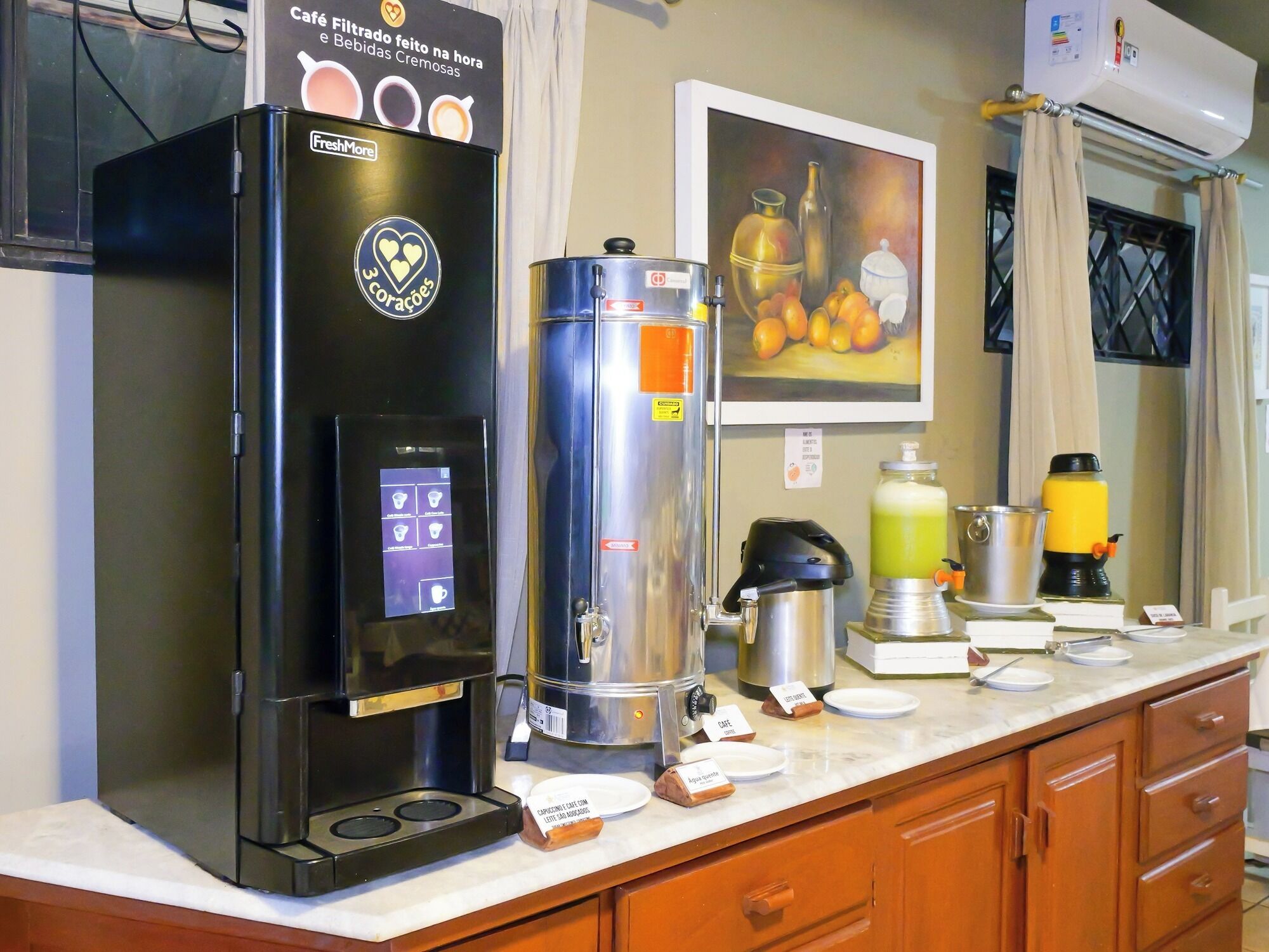 Un espace dédié au café, équipé d’une machine à café, d’un distributeur d’eau, ainsi que de différents types de tasses et de récipients pour le café.