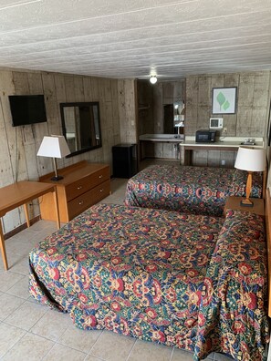 A room with two beds, a desk, a television, and a microwave. - Loma Alta Motel (Laredo)