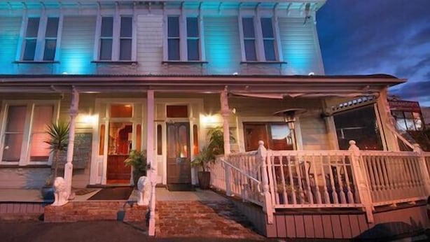 A two-story house with a porch, a front door, and a small front yard. - Shooters Saloon Bar Hotel & Cabins (Auckland)