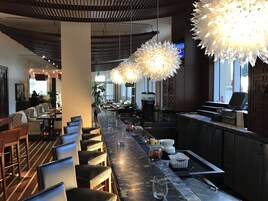 Espaço de bar com assentos e máquina de café.