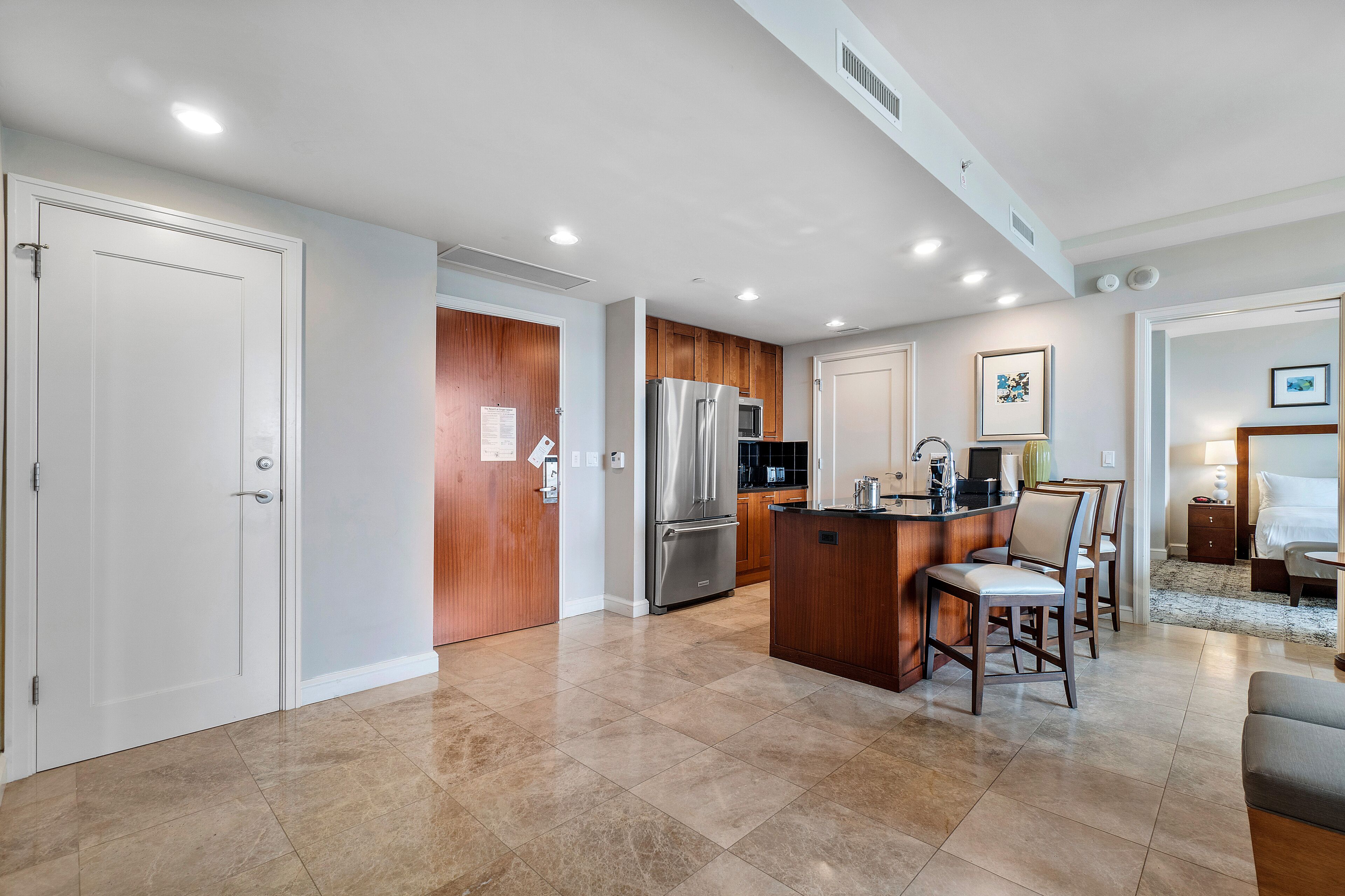 A modern kitchen with a central island, wooden cabinets, and stainless steel appliances.