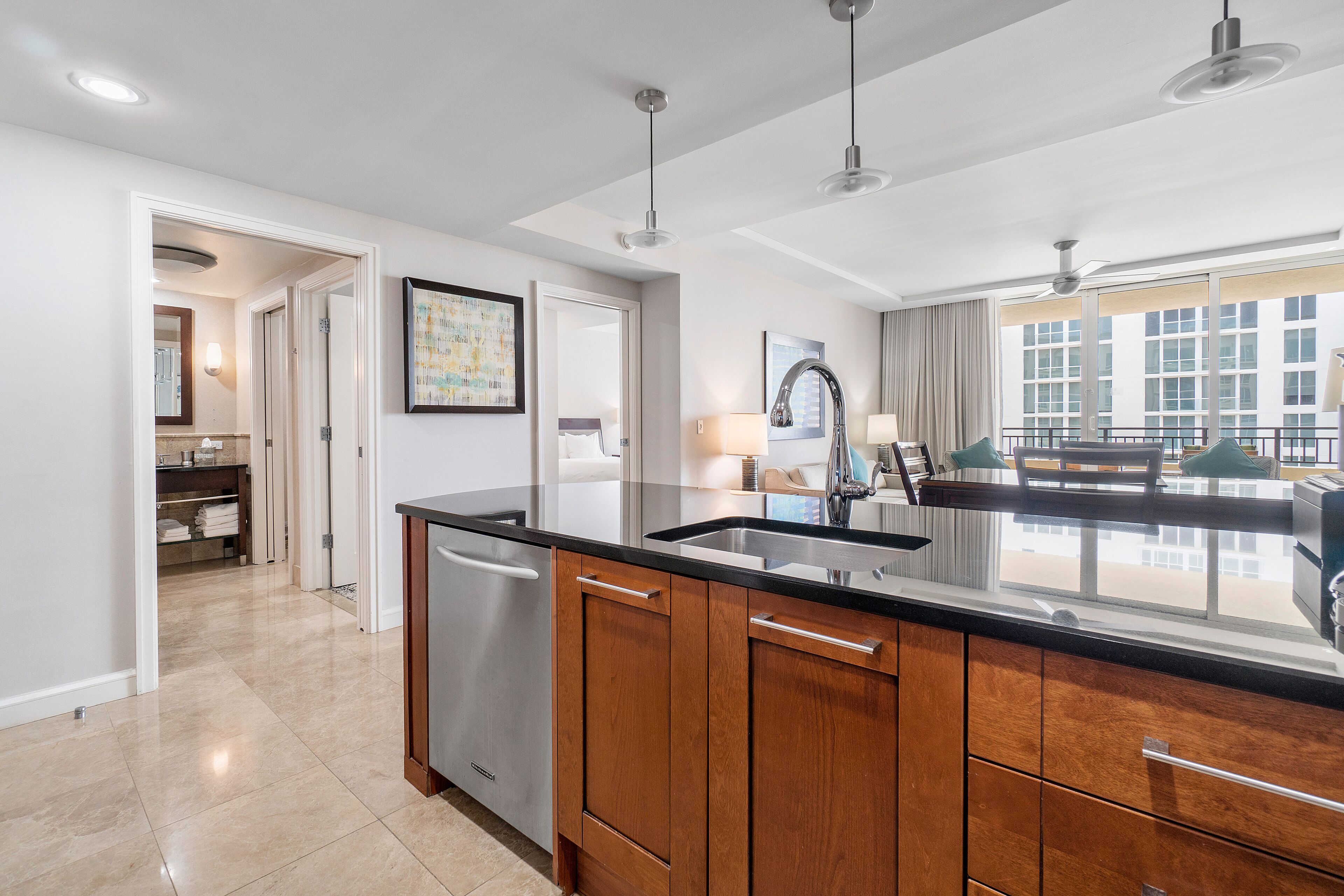 A modern kitchen with a large island, stainless steel appliances, and a view to the living area.