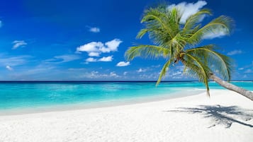 Aan een privéstrand, wit zand, strandhuisjes (toeslag), parasols