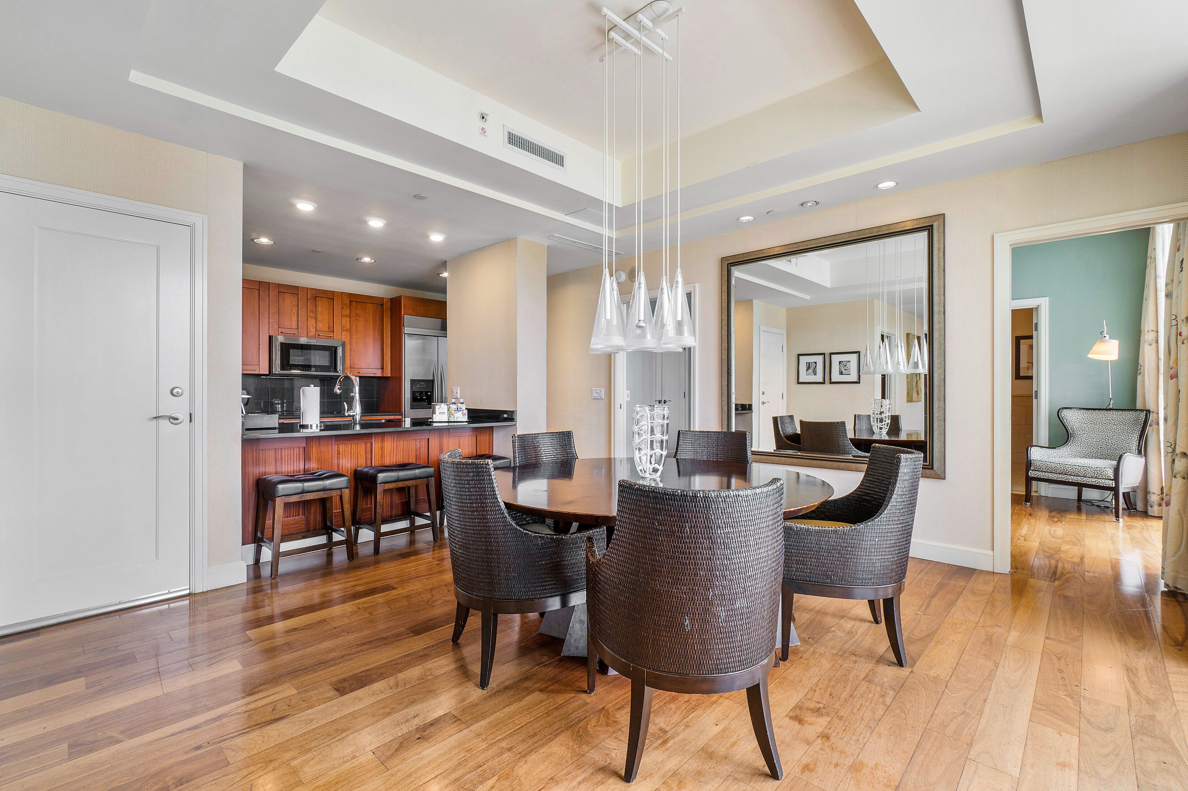 A modern kitchen with wooden cabinets, a stainless steel refrigerator, and a built-in microwave.