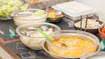 Een buffet met verschillende soorten eten, zoals salades, rijst en soep.