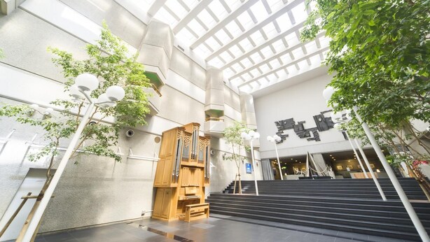 Een ruime atrium met een hoge plafond, een statige trap en een groot orgel.
