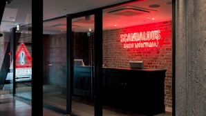 A reception area with a neon sign, a reception desk, and a glass door. - Rock Star Hotel (Osaka)