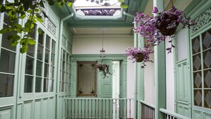 A room with a balcony, a hanging flower basket, and a view of the outside. - Hotel Casa De La Vega (Bogotá)