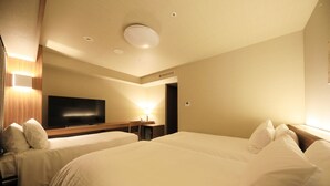 A hotel room with two beds, a flat-screen TV, a desk with a lamp, and a ceiling light. - Richmond Hotel Nagoya Shinkansenguchi (Nagoya)