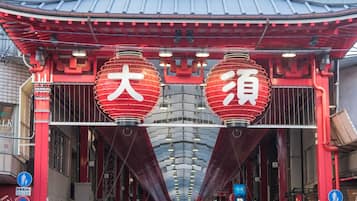 A traditional Japanese gate with red lanterns and a tiled roof.