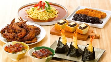 Variedade de pratos japoneses, incluindo macarrão, frango frito e sushi.