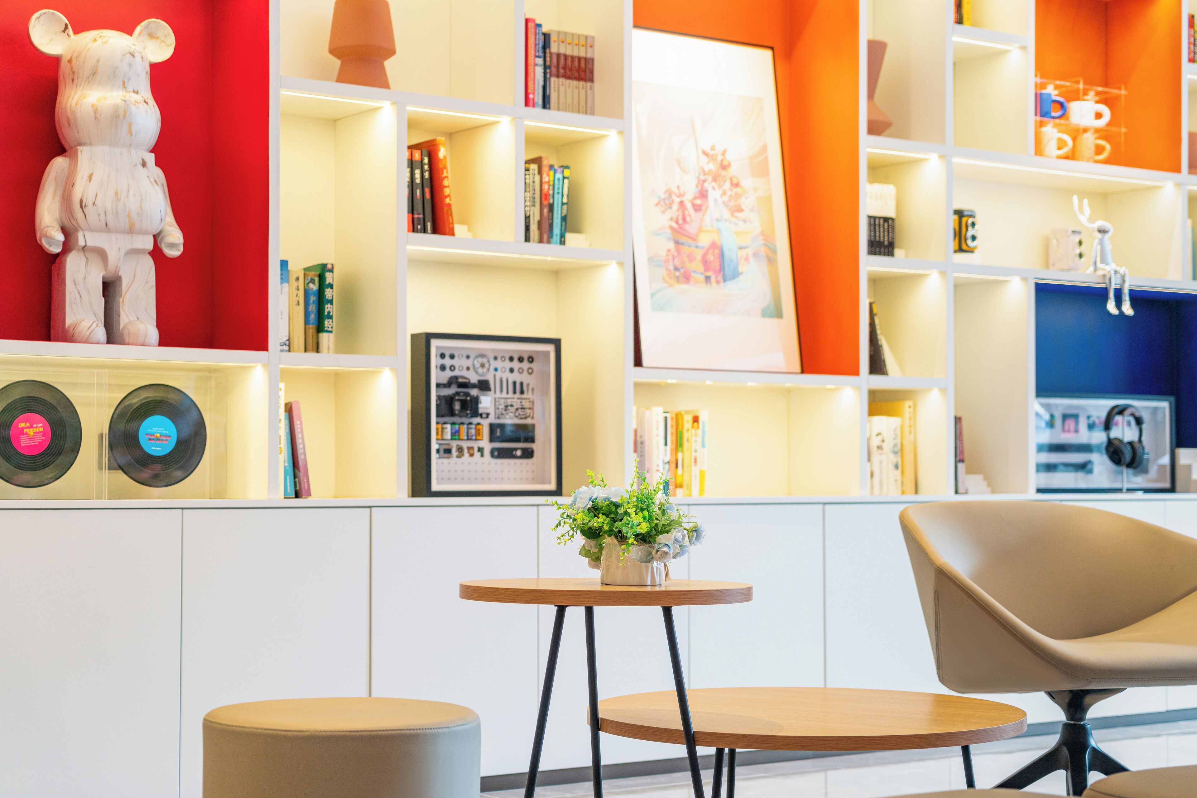 Un intérieur moderne avec une table ronde, une chaise et une bibliothèque contenant divers objets.
