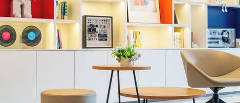 Un intérieur moderne avec une table ronde, une chaise et une bibliothèque contenant divers objets.