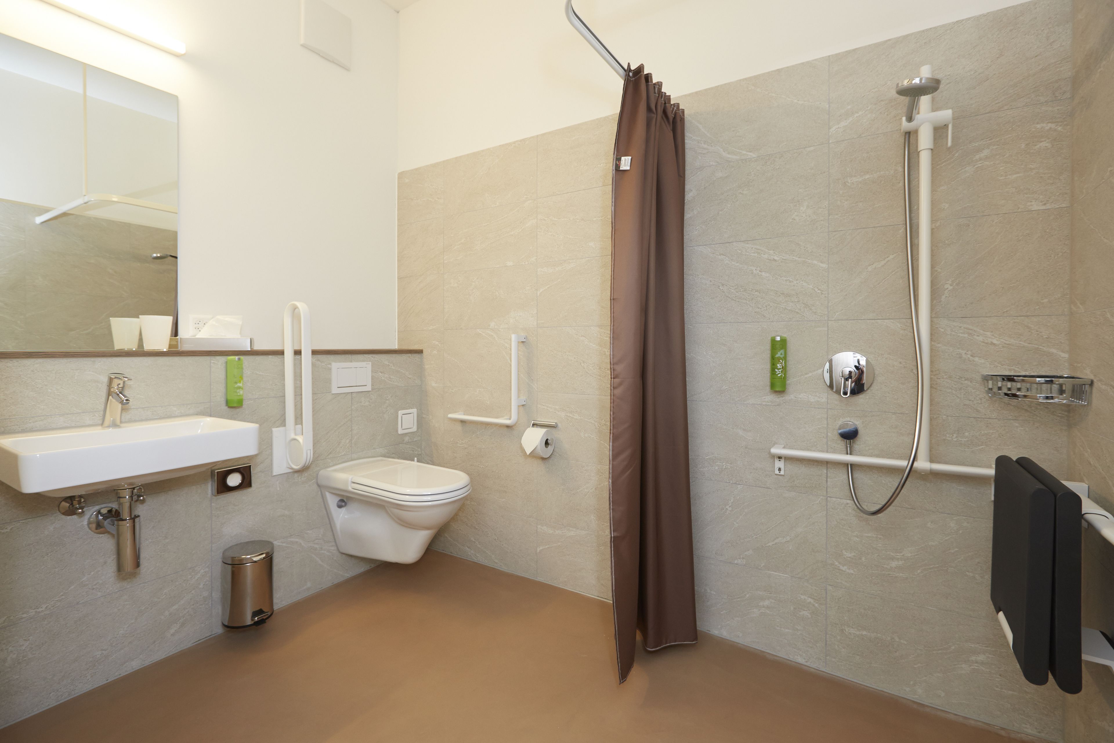 A modern bathroom with a sink, toilet, shower, and a mirror.