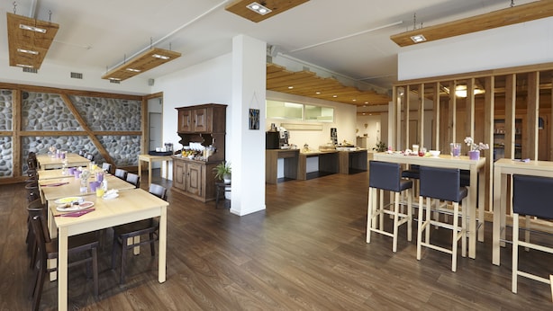Una cocina amplia con vigas de madera, una pared de acento de piedra y una isla central.