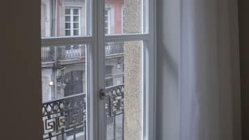 Une fenêtre donnant sur un immeuble à étages multiples et doté de balcons.