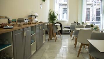 Una cocina moderna con comedor, que cuenta con un amplio ventanal, una cafetera y diversos electrodomésticos.