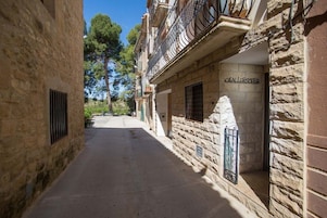 A narrow alleyway with stone buildings, a sign reading "CALLESTER", and a window with a metal gate.