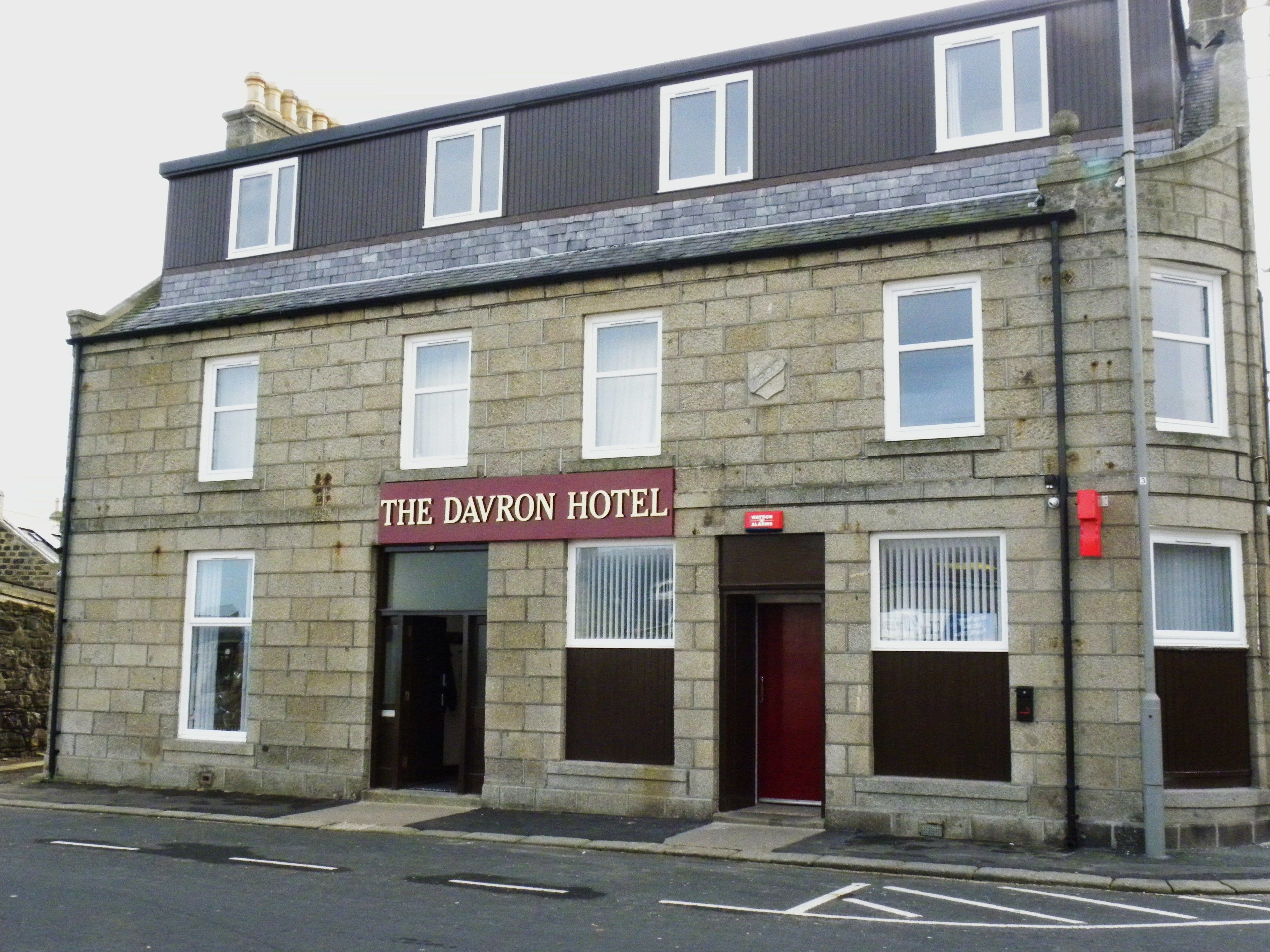 A two-story stone building with a sign reading "The Davron Hotel."