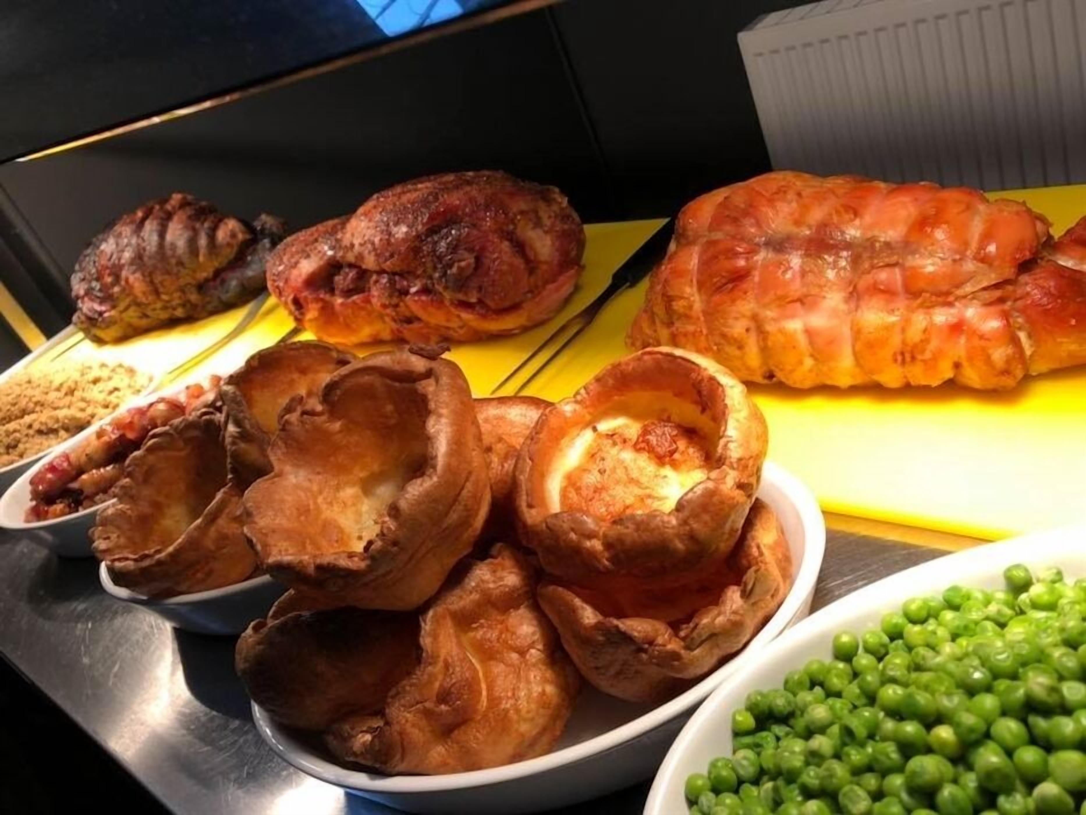 Diversos produtos de panificação, incluindo tortas e pudins Yorkshires, sobre uma mesa.