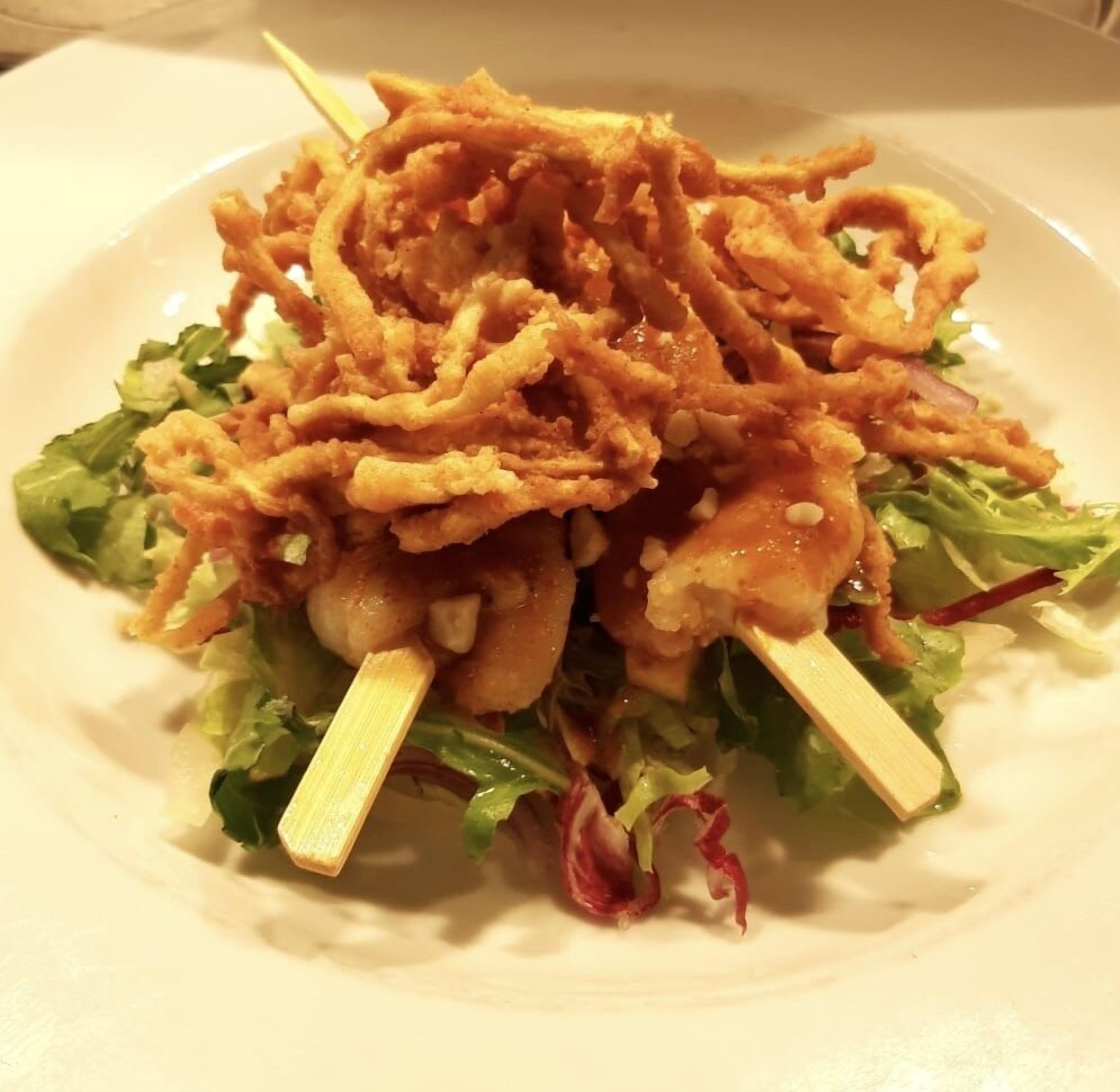 Un piatto con un'insalata e fritture.