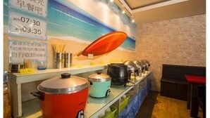 A buffet setup with various cooking pots and a wall clock displaying times. - Happy Holiday Hotel (Taoyuan City)