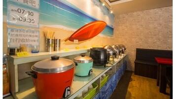 A buffet setup with various cooking pots and a wall clock displaying times.