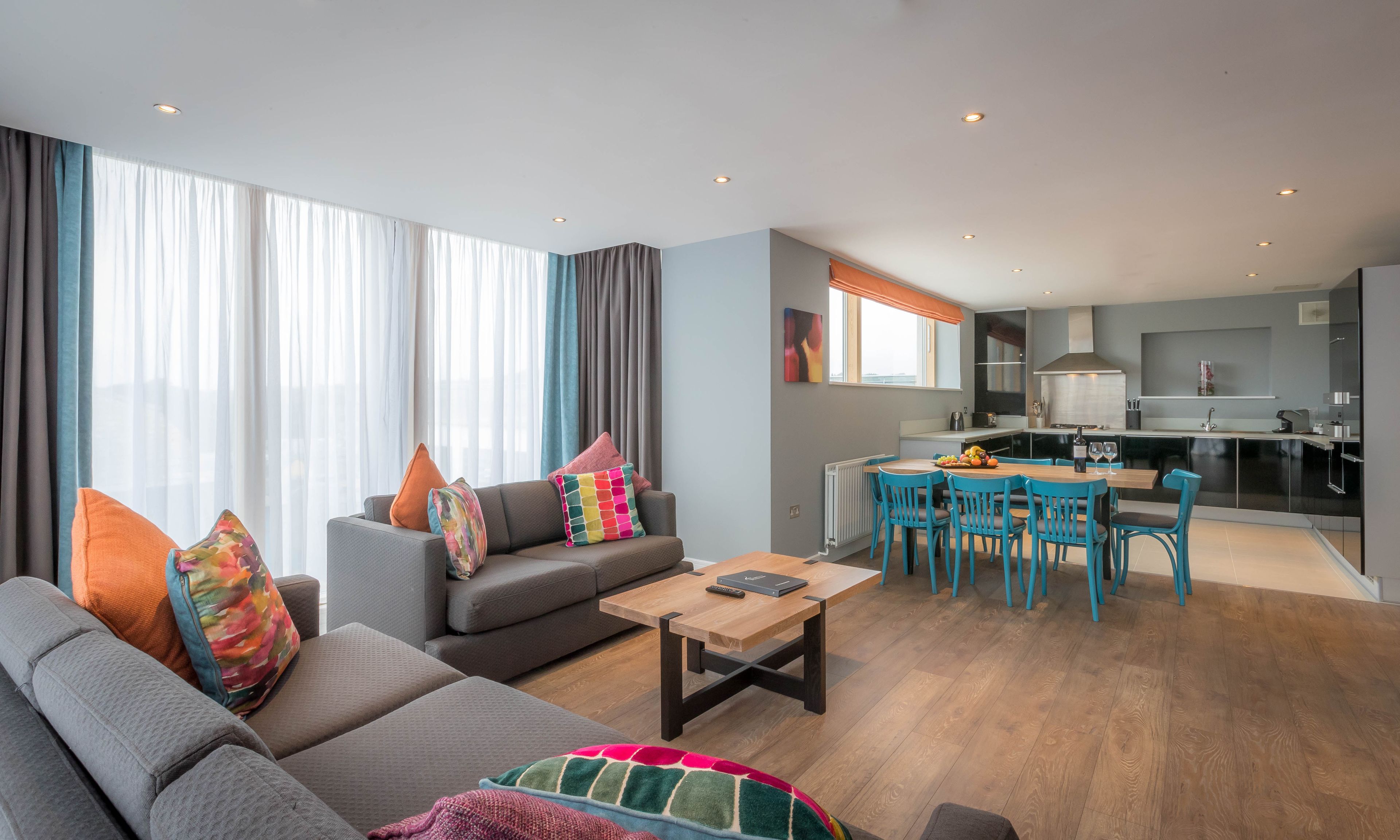 Een modern appartement met een woonkamer, eethoek en keuken.