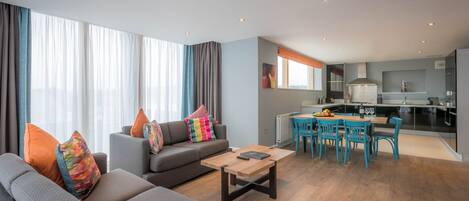 Um apartamento moderno com sala de estar, espaço para refeições e cozinha.