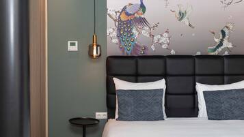 Un dormitorio moderno con una cama grande, una lámpara de pared y un adorno decorativo en la pared.