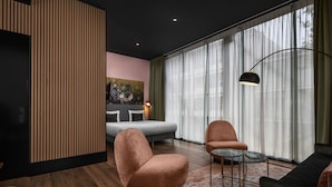A modern living room with a sofa, armchairs, a coffee table, and a painting on the wall. - Hotel2Stay (Amsterdam)