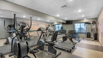 A gym with treadmills, elliptical machines, and weight equipment.