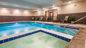 Una piscina techada, sillones reclinables de piscina