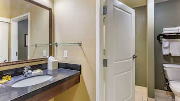 Un baño con lavabo, espejo y toallero.